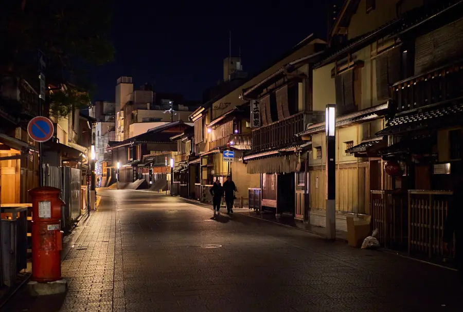 Hanamikoji street in Gion at night, lined with wooden machiya facades and glowing lanterns