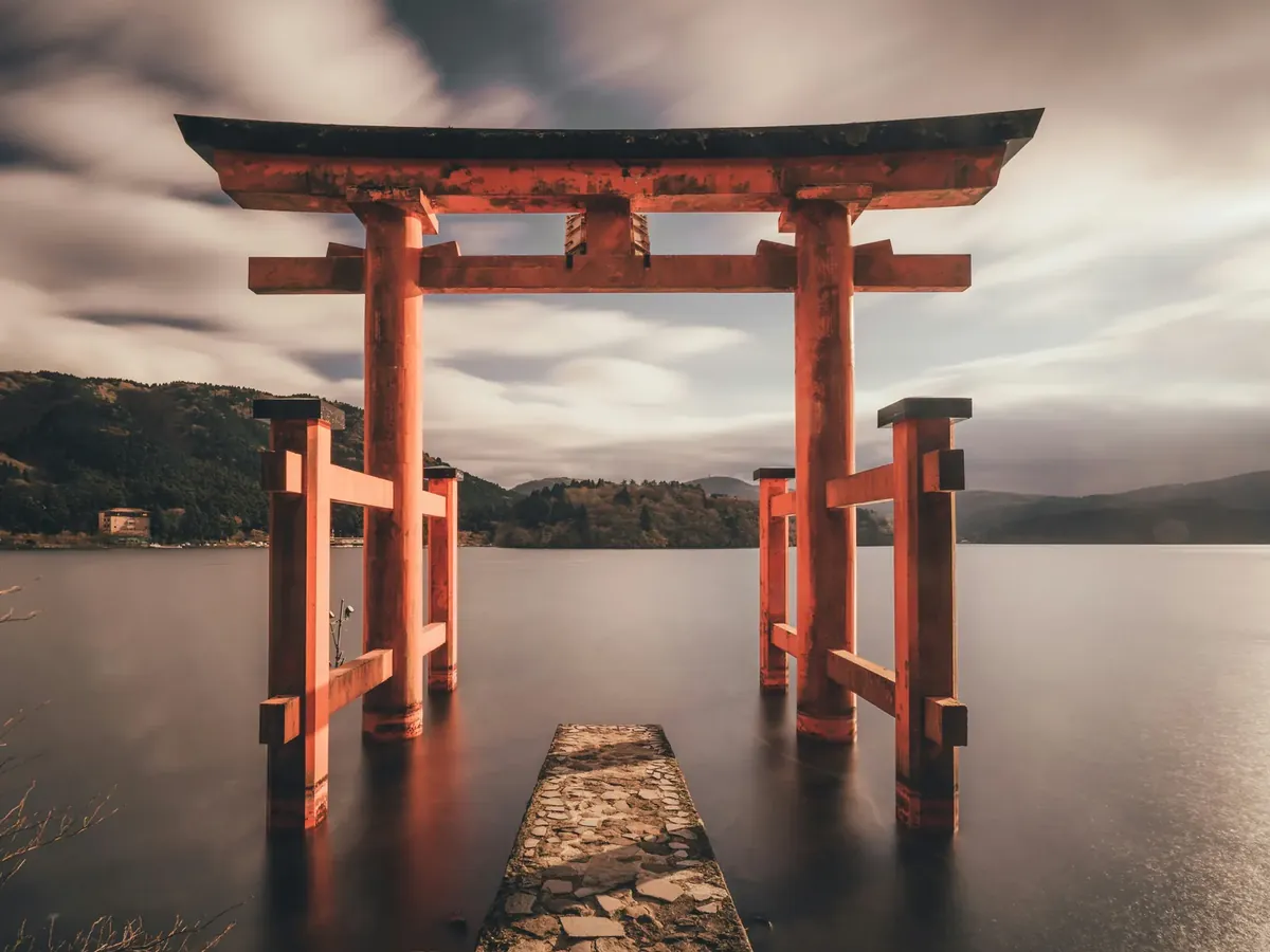 Red torii gate of Hakone Shrine standing in Lake Ashi at dusk — iconic view in a luxury Japan itinerary