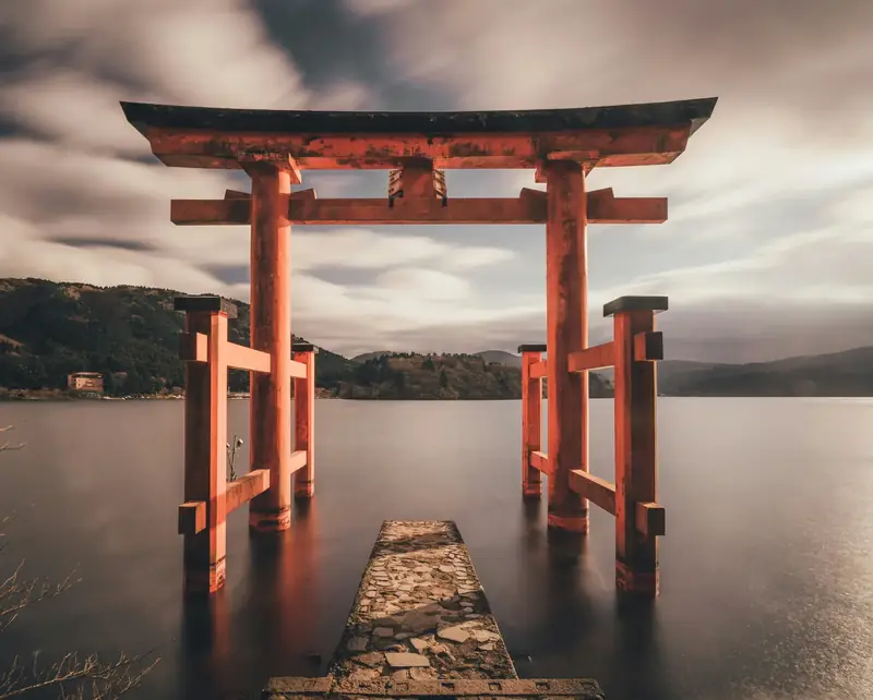 Red torii gate of Hakone Shrine standing in Lake Ashi at dusk — iconic view in a luxury Japan itinerary