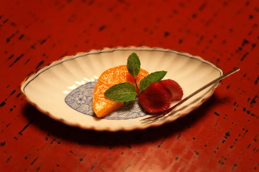 Twelfth course of a kaiseki dinner at Hiiragiya Ryokan in Kyoto: setoka orange, strawberry, and mint on blue-and-white porcelain