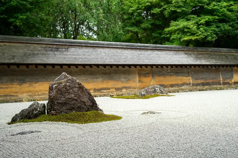 Raked gravel and a moss-ringed rock in the Ryoan-ji rock garden in Kyoto, a garden a private guide helps you read