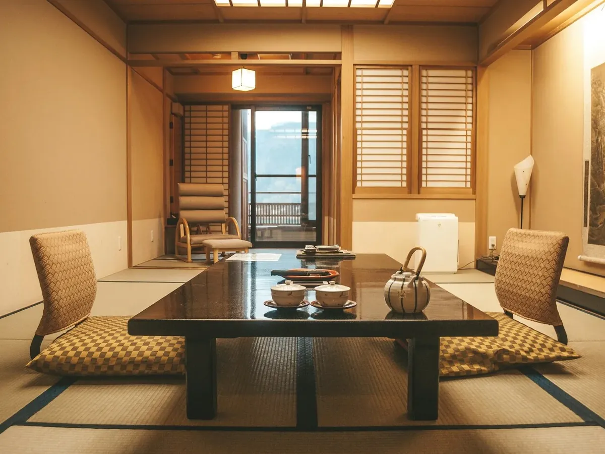 Traditional Japanese ryokan room with tatami mats, lacquered tea table and mountain view — luxury travel in Japan