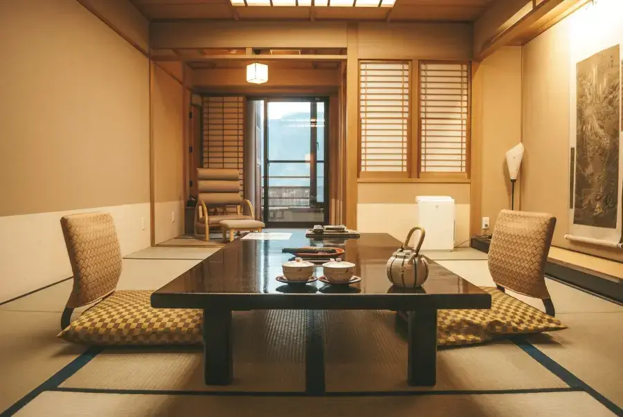 Traditional ryokan tatami room with shoji screens and low wooden furniture — the essence of Japanese inn design