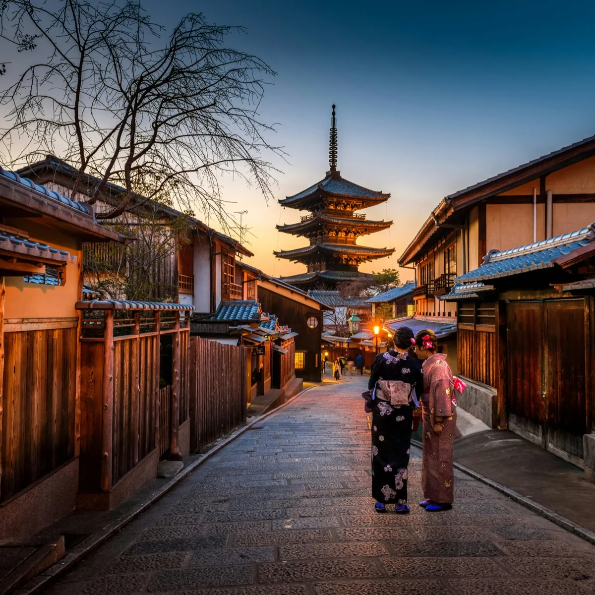Two women in kimono on the lantern-lit street to Yasaka Pagoda at dusk, Higashiyama, Kyoto