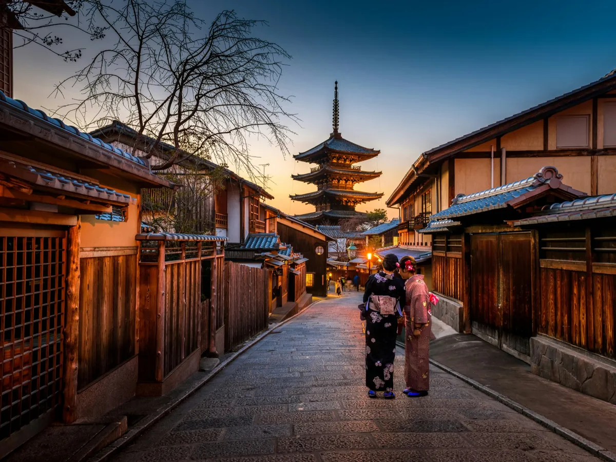 Two women in kimono on the lantern-lit street to Yasaka Pagoda at dusk, Higashiyama, Kyoto