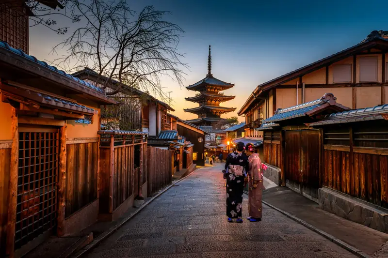 Two women in kimono on the lantern-lit street to Yasaka Pagoda at dusk, Higashiyama, Kyoto