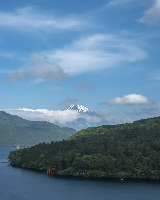 Mount Fuji seen across Lake Ashi in Hakone, a red torii gate on the shore